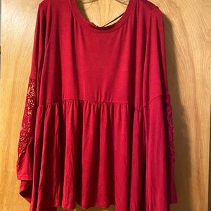 Torrid cranberry red babydoll top with lace bell sleeves and tie back. Size 2